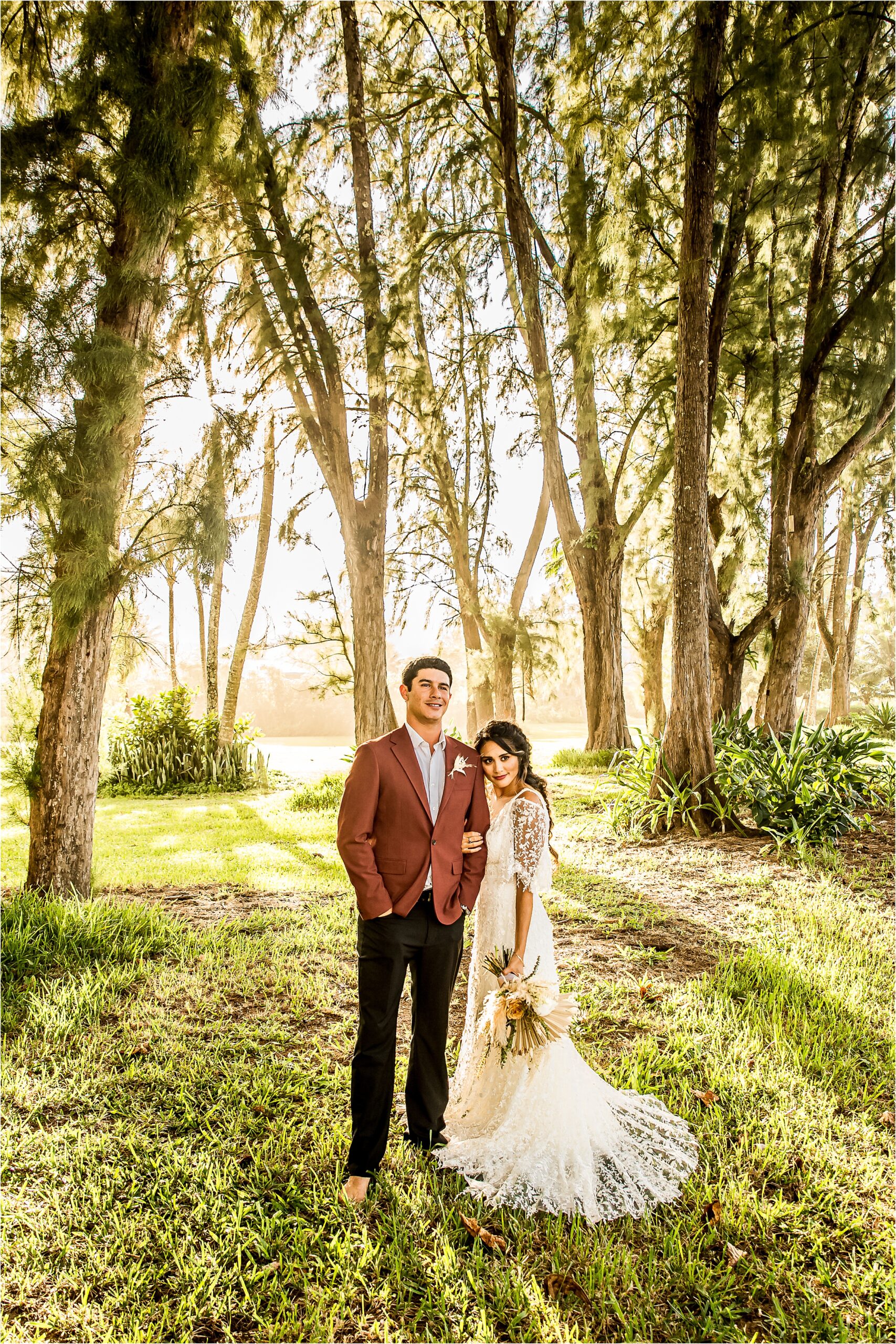 Wedding photography of man and woman forehead to forehead in wedding attire with trees in the background