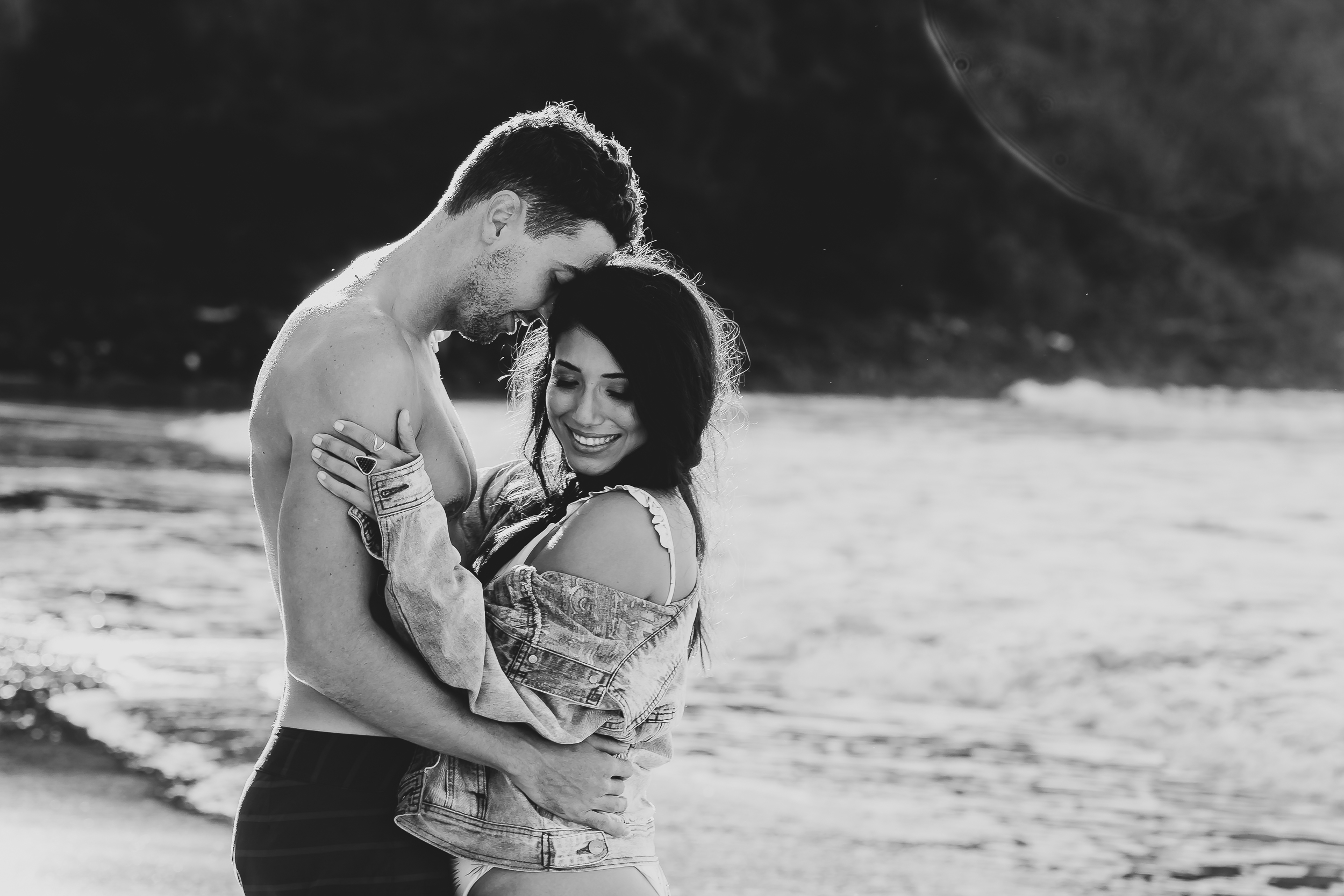 black and white image of couple hugging on the beach 